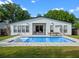Home back exterior view with a swimming pool, lounging chairs, outdoor table, and landscaped yard at 1136 W Harvard St, Orlando, FL 32804