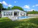 Home back exterior view with a swimming pool, lounging chairs, outdoor table, and landscaped yard at 1136 W Harvard St, Orlando, FL 32804