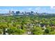A cityscape rises above lush trees surrounding neighborhood homes under a bright sky at 1136 W Harvard St, Orlando, FL 32804