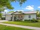 Charming exterior of home with a metal roof, landscaped lawn, and a lovely front porch sitting area at 1136 W Harvard St, Orlando, FL 32804