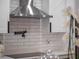 Close up of the kitchen area featuring white subway tile, stainless range hood and black pot filler faucet at 1136 W Harvard St, Orlando, FL 32804