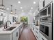 Eat-in kitchen featuring stainless steel appliances, white cabinets, quartz countertops and hardwood floors at 1136 W Harvard St, Orlando, FL 32804