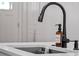 Close up of a black kitchen faucet with soap dispenser on a white kitchen island at 1136 W Harvard St, Orlando, FL 32804