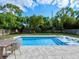 Backyard pool with clear blue water, in-pool lounging chairs, outdoor table, play set and fenced yard at 1136 W Harvard St, Orlando, FL 32804