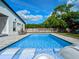 Backyard pool with clear blue water, in-pool lounging chairs, and view of the home's back exterior at 1136 W Harvard St, Orlando, FL 32804