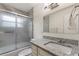 Bathroom with granite countertop vanity, glass shower door, and tiled shower at 1500 Pinecrest Pl, Orlando, FL 32803