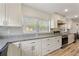 Sunlit kitchen showcasing stone countertops, white cabinetry, and stainless steel appliances at 1500 Pinecrest Pl, Orlando, FL 32803