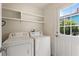 Bright laundry room with appliances, overhead shelving, and exterior door at 1500 Pinecrest Pl, Orlando, FL 32803