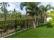 View of the fenced backyard with tropical trees and plants at 15313 Lebeau Loop, Winter Garden, FL 34787