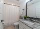 Bright bathroom featuring granite vanity, framed mirror, and shower with white shower curtain at 15313 Lebeau Loop, Winter Garden, FL 34787
