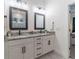 Bathroom featuring a double sink vanity with marble countertops, mirrors, and modern lighting at 15313 Lebeau Loop, Winter Garden, FL 34787