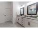 Bathroom with a double sink vanity with marble countertops, mirrors, and modern lighting at 15313 Lebeau Loop, Winter Garden, FL 34787