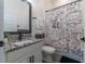 Charming bathroom with granite vanity, a decorative mirror, and a distinctive shower curtain at 15313 Lebeau Loop, Winter Garden, FL 34787