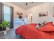 This bedroom has decor on floating shelves, a red bedspread, and gray carpet at 15313 Lebeau Loop, Winter Garden, FL 34787