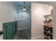 Bright laundry room with storage shelves, gray floors, a black and white runner, and green wainscoting detail at 15313 Lebeau Loop, Winter Garden, FL 34787