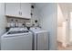 Modern laundry room with white cabinets, shelf decor, and a new Samsung washer and dryer at 15313 Lebeau Loop, Winter Garden, FL 34787
