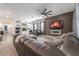 Spacious living room featuring a leather sectional sofa, custom wood accent wall, and built-in desk area at 15313 Lebeau Loop, Winter Garden, FL 34787