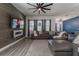 Spacious living room with a large sectional sofa, modern fireplace, and wood accent wall at 15313 Lebeau Loop, Winter Garden, FL 34787