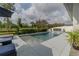 Backyard pool featuring a sun shelf, landscape views, and outdoor lighting at 15313 Lebeau Loop, Winter Garden, FL 34787