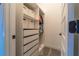 A closet with white storage cabinets and a variety of hanging clothing at 15313 Lebeau Loop, Winter Garden, FL 34787