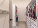 A closet with white storage cabinets, shelves and hanging clothing at 15313 Lebeau Loop, Winter Garden, FL 34787