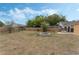 Spacious backyard featuring a stone fire pit, mature trees, and a wooden fence for added privacy at 2051 Pernod Ct, Apopka, FL 32703