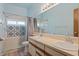 Well-lit bathroom featuring a double vanity and a tiled shower with decorative accents at 2051 Pernod Ct, Apopka, FL 32703