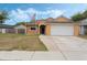 Charming one-story home with a two-car garage, neat landscaping, and an American flag at 2051 Pernod Ct, Apopka, FL 32703