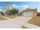 One-story home with a two-car garage, neutral paint, long driveway, and well-manicured lawn at 2051 Pernod Ct, Apopka, FL 32703