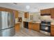 Updated kitchen featuring stainless steel appliances, wooden cabinets, and an open view to the fireplace at 2051 Pernod Ct, Apopka, FL 32703