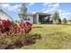Lush backyard showcasing a green lawn, a screened patio, and colorful flower beds for added charm at 2587 Cliff Way, St Cloud, FL 34771