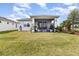Spacious backyard featuring a well-maintained lawn, screened patio, and manicured landscaping at 2587 Cliff Way, St Cloud, FL 34771