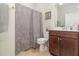 Well-lit bathroom featuring a tile floor, decorative shower curtain and a vanity with dark wood cabinets at 2587 Cliff Way, St Cloud, FL 34771