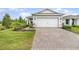 Exterior view of two-car garage with brick-paved driveway and manicured front yard at 2587 Cliff Way, St Cloud, FL 34771