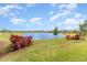 Scenic view of a tranquil pond bordered by green grass and tidy landscaping under a clear sky at 2587 Cliff Way, St Cloud, FL 34771