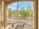 Relaxing screened balcony with seating offering views of the parking area and mature trees at 2781 Almaton Loop # 203, Kissimmee, FL 34747
