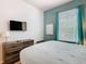 Bedroom with modern gray furnishings, neutral comforter, and light-filtering window shades at 2781 Almaton Loop # 203, Kissimmee, FL 34747