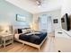 Well-lit bedroom boasts a ceiling fan, art, nightstands, and a comfortable bed with decorative pillows at 2781 Almaton Loop # 203, Kissimmee, FL 34747