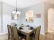 Dining room features a rustic wood table, seating for six, and arched window into the kitchen at 2781 Almaton Loop # 203, Kissimmee, FL 34747