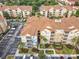 Scenic aerial view of condo with parking, landscaping, and exterior showing private balcony with tropical landscaping at 2781 Almaton Loop # 203, Kissimmee, FL 34747