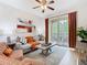 Bright living room with comfortable seating, balcony access, ceiling fan, and neutral decor at 2781 Almaton Loop # 203, Kissimmee, FL 34747