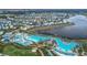 Extensive aerial view showcasing vibrant homes, a large resort pool, and serene waterfront views at 3205 Caribbean Soul Dr, Kissimmee, FL 34747