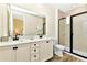 Bathroom featuring double sink vanity, framed mirror, and walk-in shower with neutral tones at 3205 Caribbean Soul Dr, Kissimmee, FL 34747