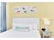 Inviting bedroom with a plush queen bed, bedside table, and charming beach-themed decor at 3205 Caribbean Soul Dr, Kissimmee, FL 34747