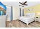 Bright bedroom featuring a queen bed with white bedding, colorful artwork, and wood-look floors at 3205 Caribbean Soul Dr, Kissimmee, FL 34747