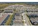Aerial view of a new neighborhood near a school, featuring uniform housing, landscaping, and pools at 3273 Lilac Way, Davenport, FL 33897