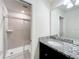 Modern bathroom featuring a glass-enclosed shower and stylish granite countertop at 3273 Lilac Way, Davenport, FL 33897