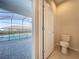 Bathroom with toilet and view of covered lanai and pool at 3273 Lilac Way, Davenport, FL 33897