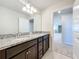 Bathroom featuring granite countertop, dual sinks, dark cabinetry, and stylish lighting fixtures at 3273 Lilac Way, Davenport, FL 33897