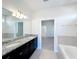 Bathroom vanity has granite countertop and dual sinks next to a tiled tub at 3273 Lilac Way, Davenport, FL 33897
